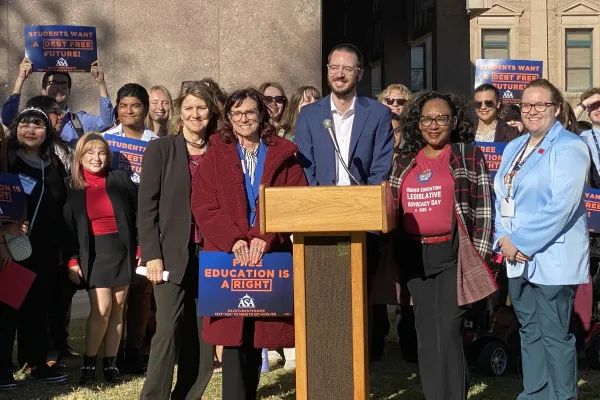 Several people standing behind a podium outside the Arizona State Capitol.