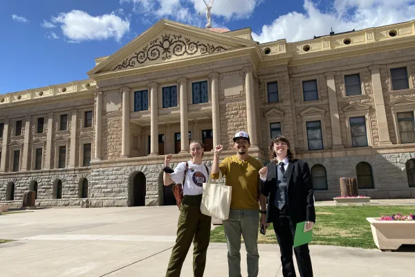 Three people standing in front of the Arizona State Capitol museum building.