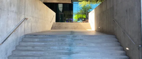 Daytime picture of the cement staircase leading from the Optical Sciences building to the Grand Challenges building at the University of Arizona.